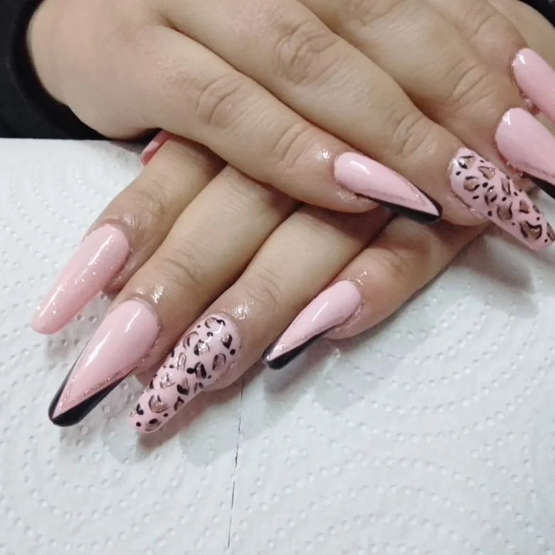 Uñas largas en rosa con detalles de animal print y bordes negros, hechas en Quimey